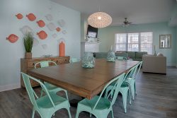 beach themed dining area with teal chairs and coral accents