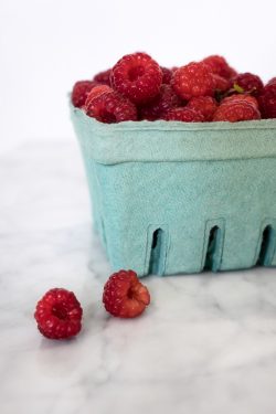 pint of fresh raspberries in a green container
