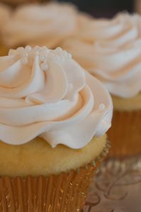 yellow cupcakes with cream icing and white sprinkles