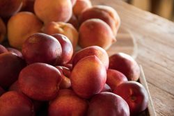 fresh nectarines and peaches on a butcher block counter