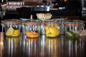 orange lemons and lime in mason jars used for garnishing drinks at a bar