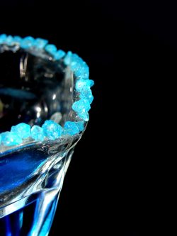electric blue drink with blue crystals lining the rim of the glass