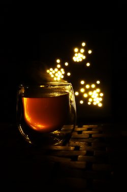 steaming cup of tea against a dark background
