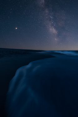 ocean beach at night with milky way galaxy