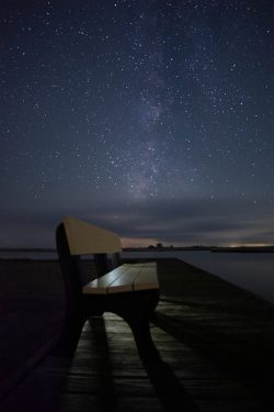 bench on dock at night with stars milkyway
